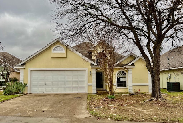 view of front of home with a garage and central air condition unit