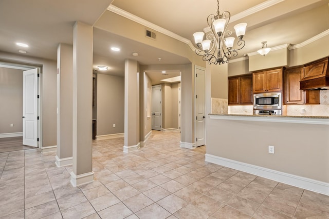 kitchen featuring backsplash, ornamental molding, decorative light fixtures, an inviting chandelier, and stainless steel microwave