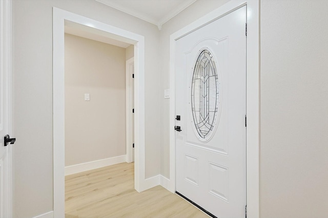 entrance foyer with ornamental molding and light hardwood / wood-style floors