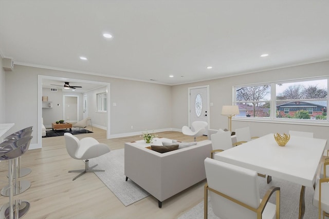 living room featuring ornamental molding, light hardwood / wood-style floors, and ceiling fan