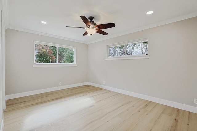 spare room featuring ornamental molding, a wealth of natural light, and light hardwood / wood-style flooring