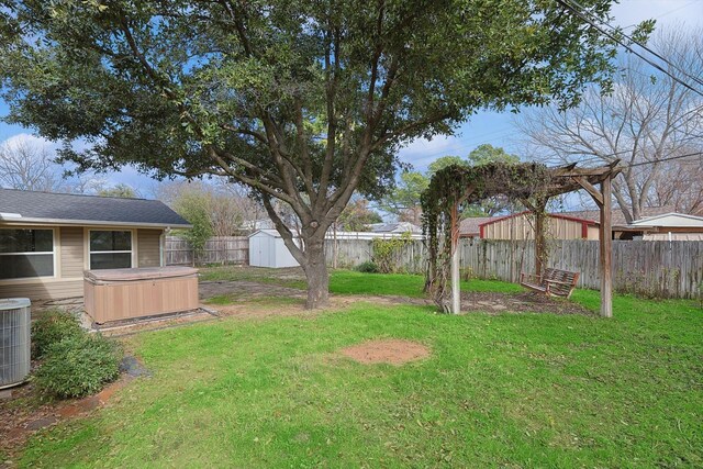 1016 Cavender Dr, Hurst, TX 76053 - view of yard featuring a storage shed, a hot tub, central air condition unit, an outdoor structure, and a fenced backyard