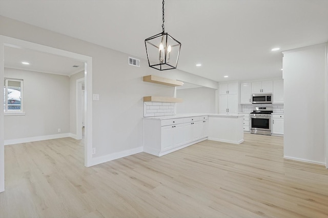 kitchen with pendant lighting, light hardwood / wood-style flooring, appliances with stainless steel finishes, tasteful backsplash, and white cabinets