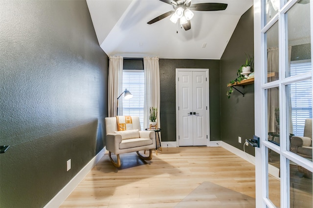 sitting room with a healthy amount of sunlight, vaulted ceiling, and wood-type flooring