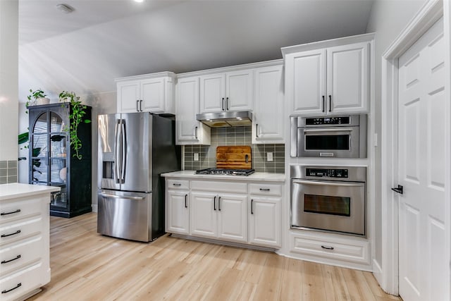 kitchen featuring decorative backsplash, white cabinetry, light hardwood / wood-style flooring, and appliances with stainless steel finishes