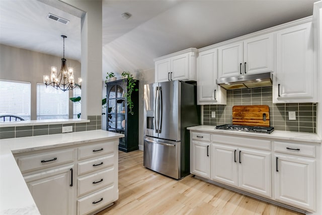 kitchen featuring an inviting chandelier, decorative backsplash, light hardwood / wood-style floors, white cabinetry, and stainless steel appliances