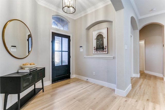 foyer featuring a notable chandelier, light hardwood / wood-style floors, and ornamental molding