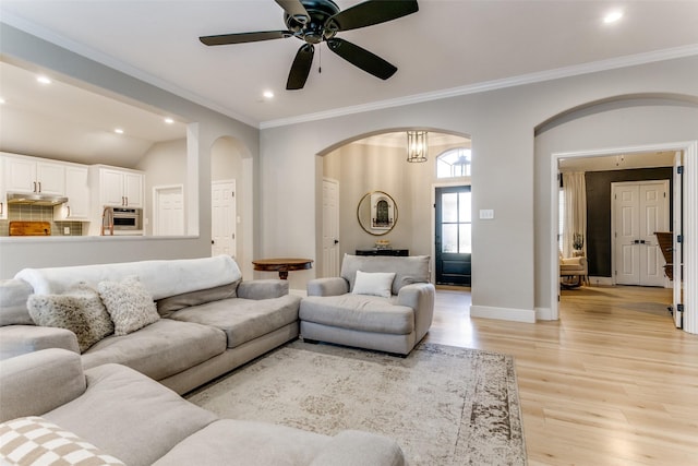 living room featuring light hardwood / wood-style flooring, ceiling fan, and crown molding