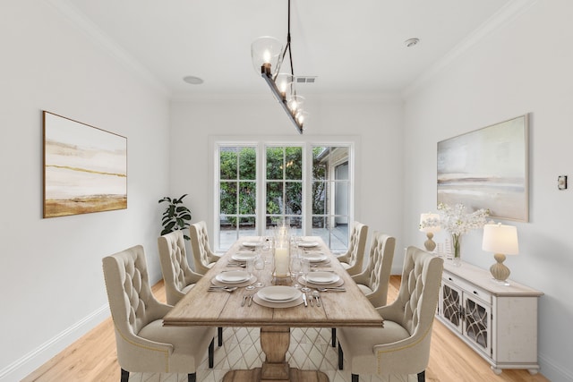 dining room featuring ornamental molding and light wood-type flooring