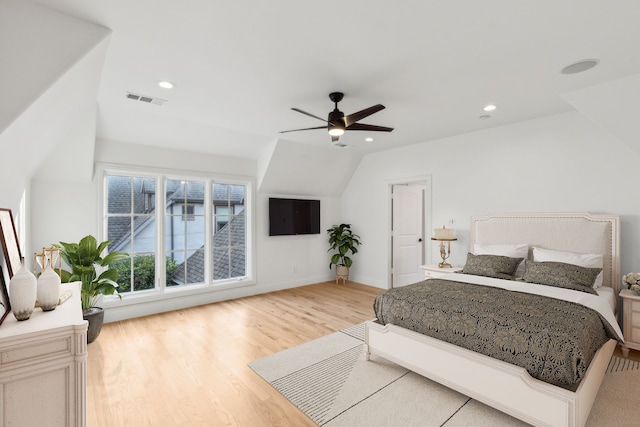 bedroom featuring ceiling fan, light wood-type flooring, and lofted ceiling