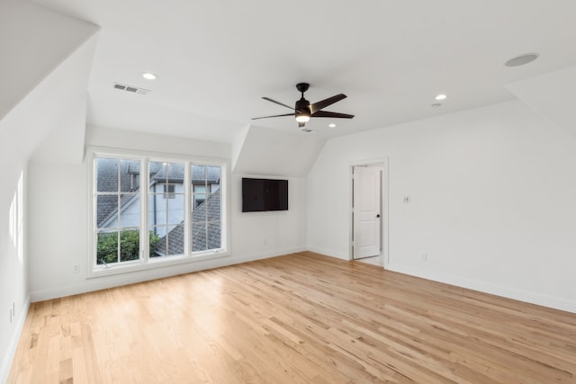 unfurnished living room featuring ceiling fan, vaulted ceiling, and light hardwood / wood-style flooring