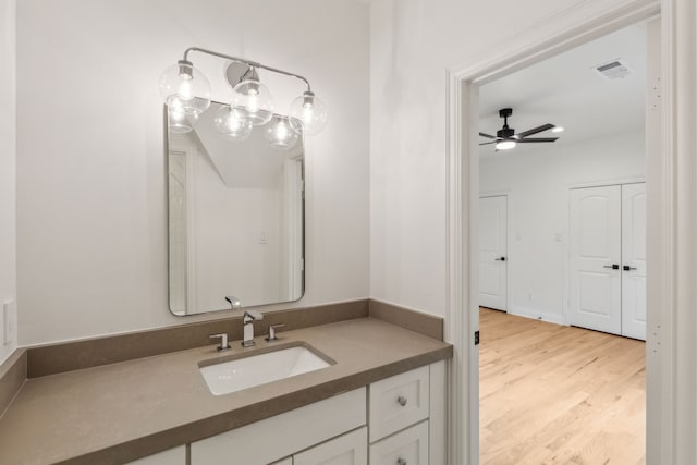 bathroom with wood-type flooring, vanity, and ceiling fan