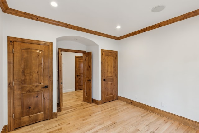 unfurnished bedroom with ornamental molding and light hardwood / wood-style flooring