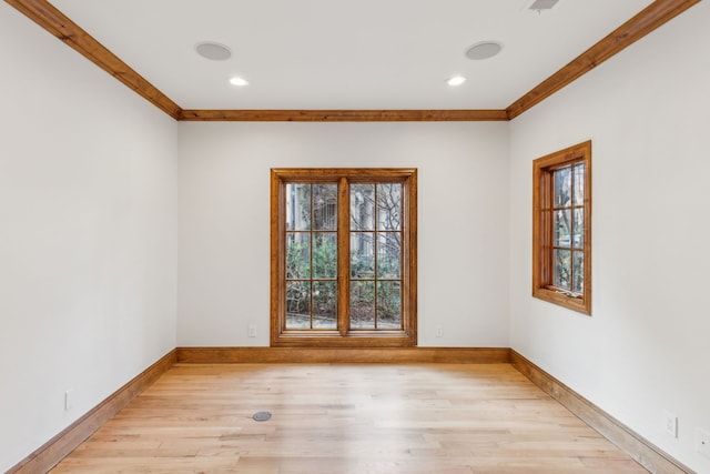 spare room featuring light wood-type flooring and ornamental molding