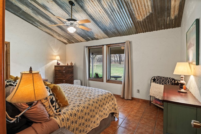 bedroom featuring dark tile patterned flooring, vaulted ceiling, and ceiling fan