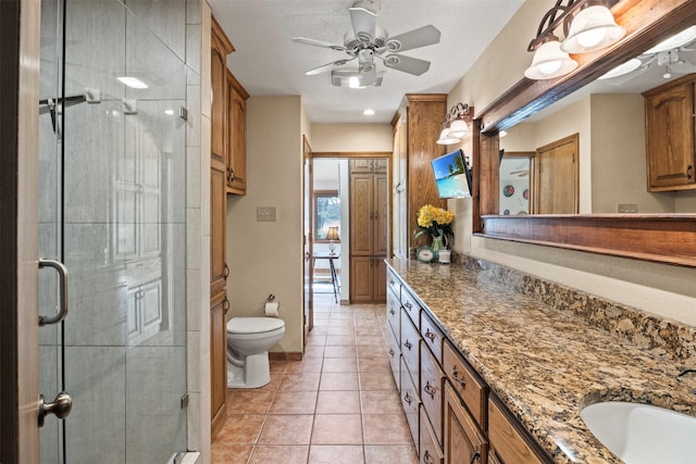 bathroom featuring tile patterned flooring, vanity, toilet, and an enclosed shower