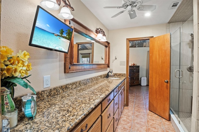 bathroom featuring tile patterned floors, ceiling fan, a shower with shower door, and vanity