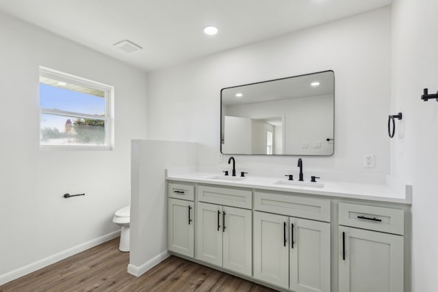 bathroom featuring wood-type flooring, vanity, and toilet