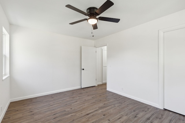 empty room with ceiling fan and dark wood-type flooring