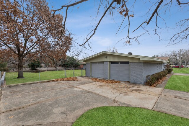 exterior space featuring a lawn, an outbuilding, and a garage