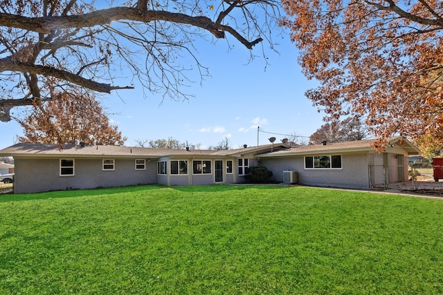 rear view of property featuring a yard and central air condition unit