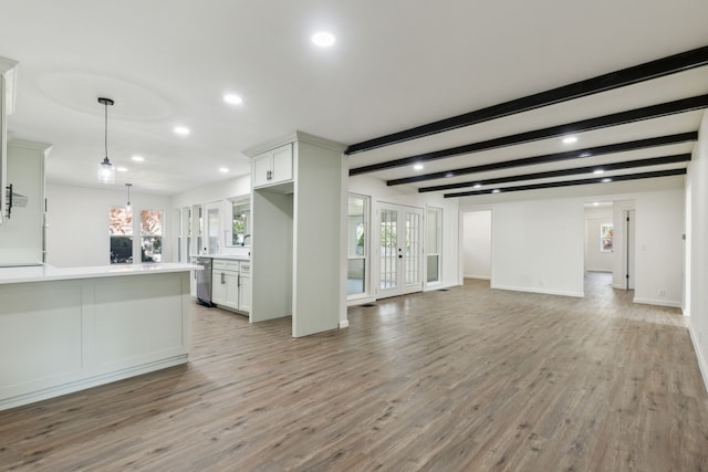 unfurnished living room with beamed ceiling, french doors, light hardwood / wood-style flooring, and a wealth of natural light