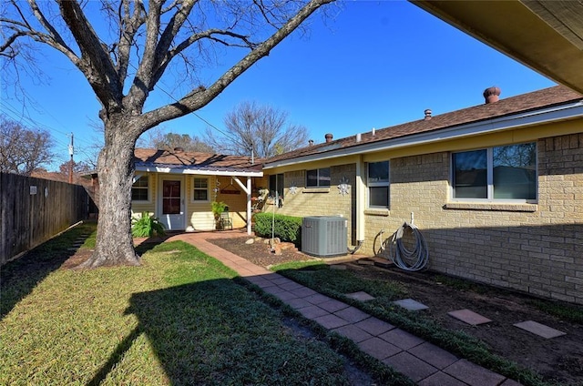 back of property with a yard and central AC unit