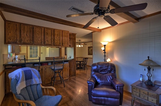 interior space featuring beam ceiling, ceiling fan, dark wood-type flooring, white fridge, and a textured ceiling