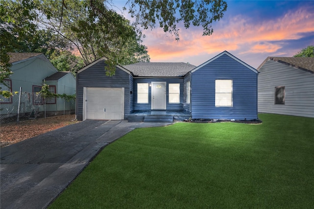 ranch-style house with a garage and a lawn