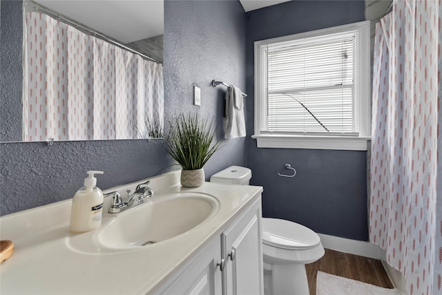 bathroom featuring wood-type flooring, vanity, and toilet