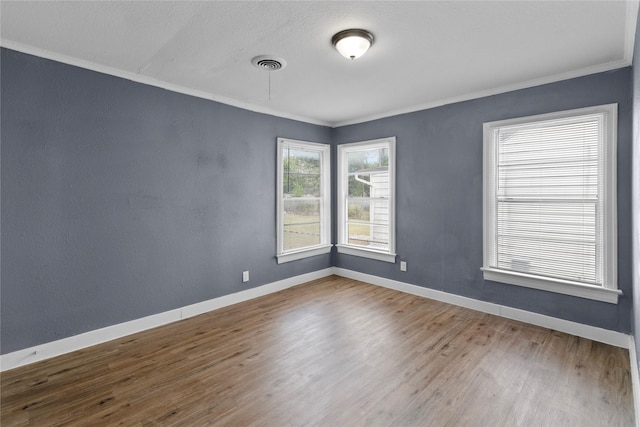 empty room with hardwood / wood-style floors and ornamental molding