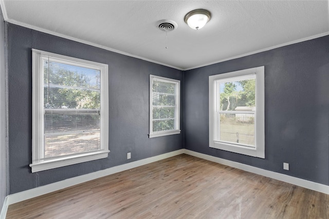 empty room with light hardwood / wood-style floors and ornamental molding