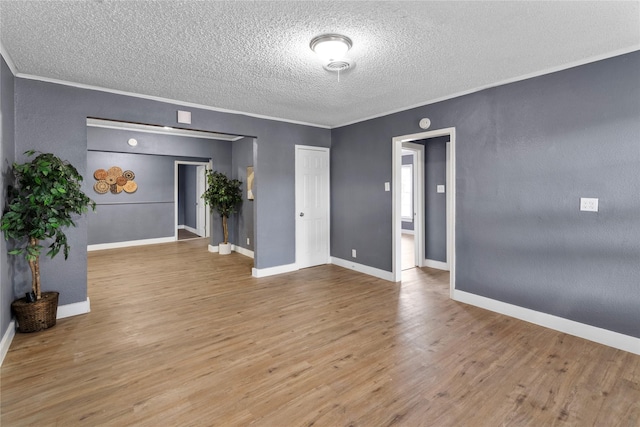 unfurnished room featuring crown molding, a textured ceiling, and light hardwood / wood-style flooring