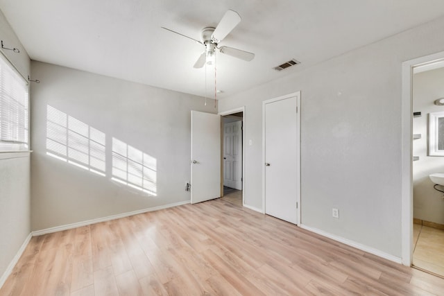 unfurnished bedroom featuring light wood-type flooring, ceiling fan, and connected bathroom