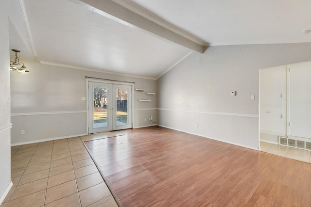 tiled spare room featuring ornamental molding, lofted ceiling with beams, and french doors