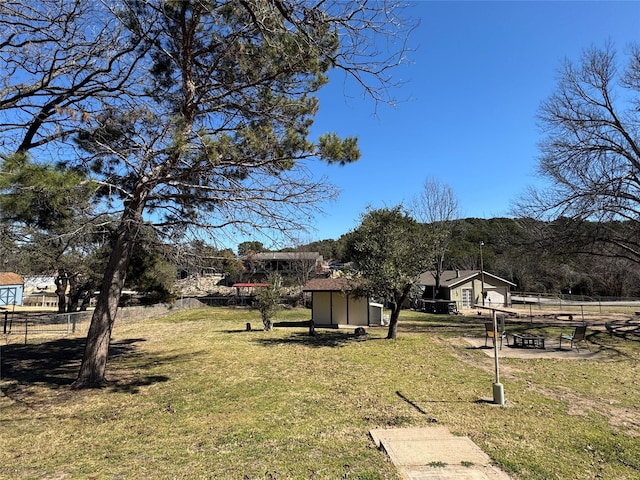 view of yard featuring a storage shed, an outdoor structure, and fence