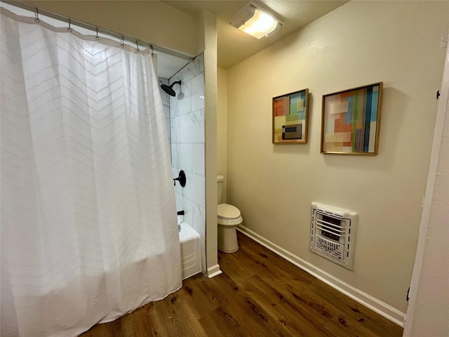 bathroom featuring heating unit, toilet, shower / bath combo, and hardwood / wood-style flooring