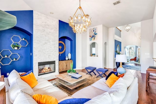 living room with a fireplace, a notable chandelier, and hardwood / wood-style flooring