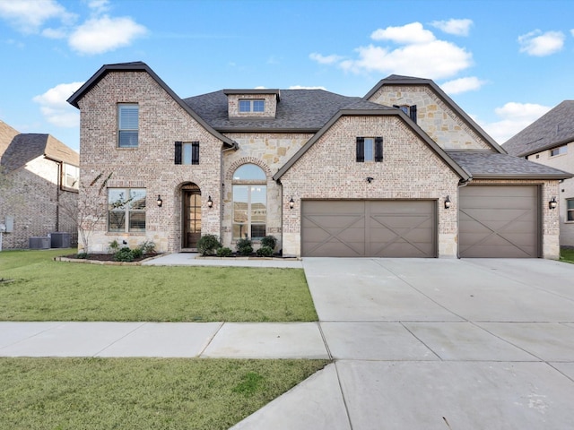 french country home with cooling unit, a garage, and a front yard