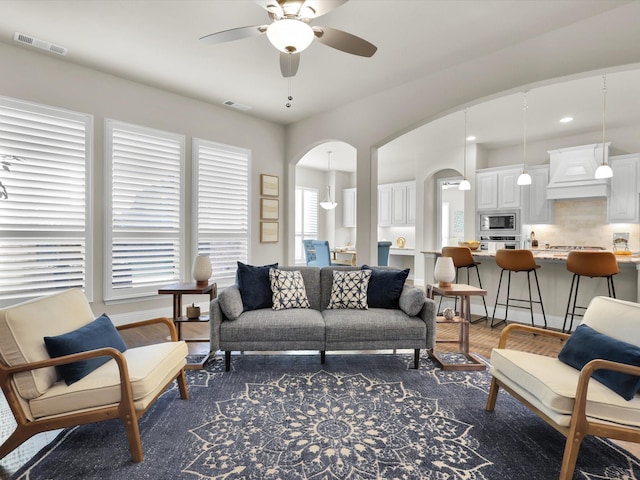 living room with dark hardwood / wood-style floors and ceiling fan