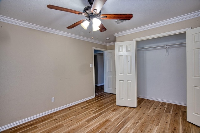 unfurnished bedroom with ceiling fan, a closet, crown molding, and light hardwood / wood-style flooring