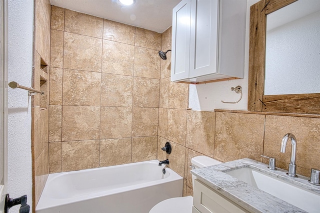 full bathroom with toilet, vanity, tile walls, and tiled shower / bath