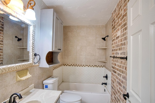 full bathroom featuring toilet, vanity, tile walls, tiled shower / bath combo, and decorative backsplash