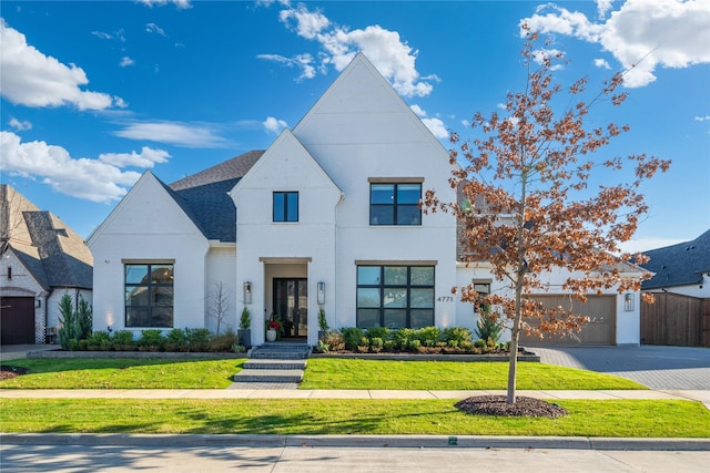 view of front of property featuring a garage and a front lawn