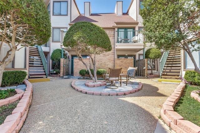 view of front of house featuring a balcony and a patio area