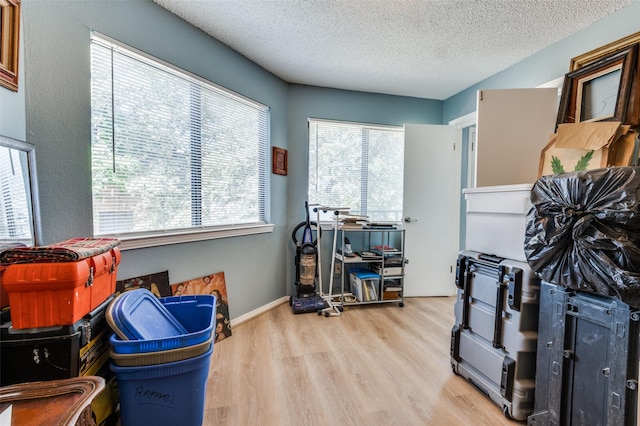 miscellaneous room with a textured ceiling and light wood-type flooring