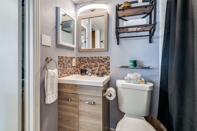 bathroom with vanity, backsplash, and toilet