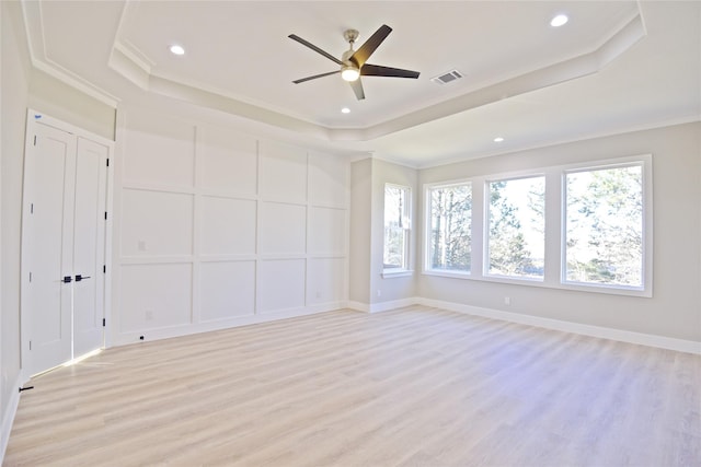 spare room featuring ornamental molding, light hardwood / wood-style flooring, and a tray ceiling