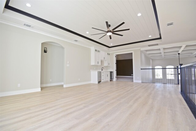 unfurnished living room featuring coffered ceiling, ceiling fan, light wood-type flooring, ornamental molding, and wood ceiling