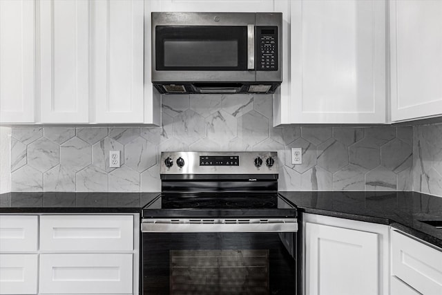 kitchen featuring tasteful backsplash, stainless steel appliances, dark stone counters, and white cabinets